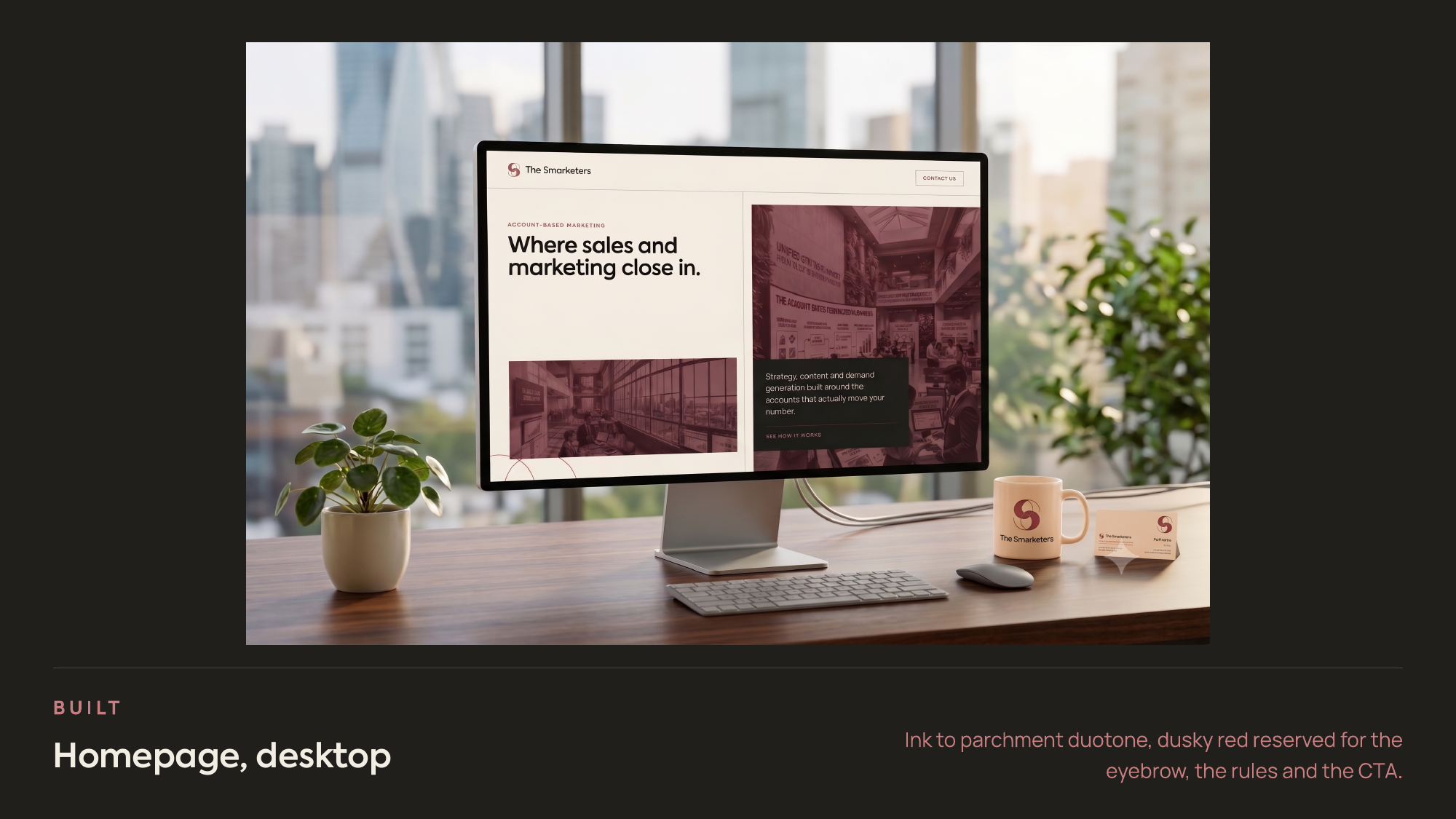 The redesigned homepage shown on a desktop monitor in an office setting, with branded mugs beside it